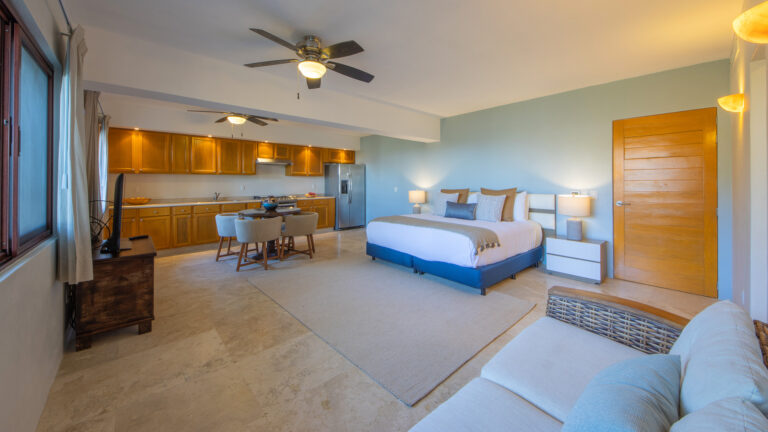 Villa Magnifico Bright modern bedroom with bed, sofa, dining area, and kitchen in Mismaloya near Puerto Vallarta, Mexico.
