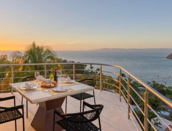 Villa Magnifico Terrace in Mismaloya, near Puerto Vallarta, with ocean sunset view; dining table set for four.