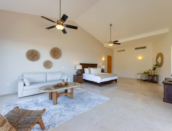 Villa Magnifico Elegant bedroom with king bed, sofa, wooden accents, and decorative baskets in Mismaloya near Puerto Vallarta.