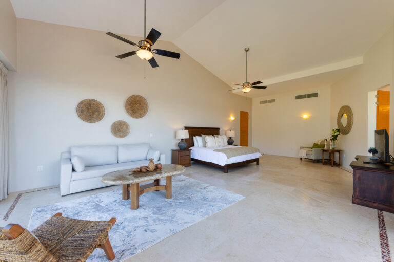 Villa Magnifico Elegant bedroom with king bed, sofa, wooden accents, and decorative baskets in Mismaloya near Puerto Vallarta.