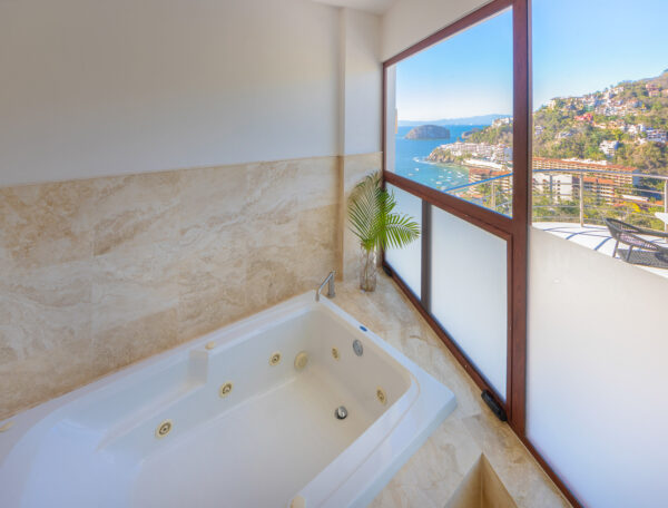 Villa Magnifico Luxurious bathroom in Mismaloya, near Puerto Vallarta: Whirlpool bathtub, marble, coastal view of blue waters and green hills.