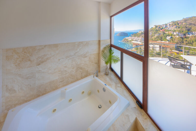 Villa Magnifico Luxurious bathroom in Mismaloya, near Puerto Vallarta: Whirlpool bathtub, marble, coastal view of blue waters and green hills.