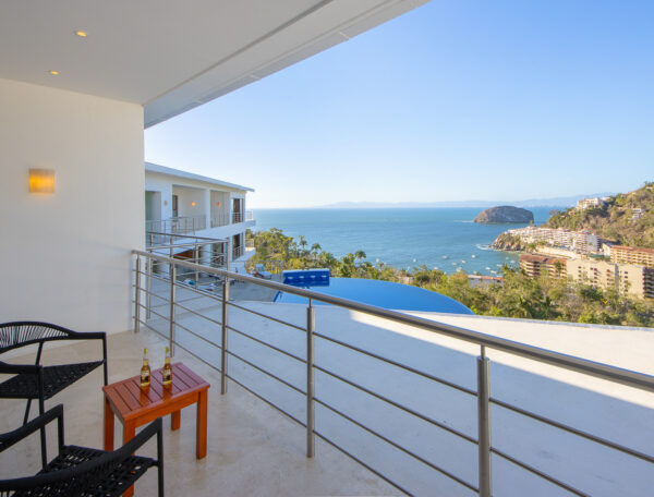 Villa Magnifico In Mismaloya, near Puerto Vallarta, Mexico: Ocean-view balcony with two chairs, table, and scenic hills visible.