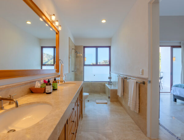 Villa Magnifico Modern bathroom with marble floors, double sink, and walk-in shower. Located in Mismaloya, near Puerto Vallarta.