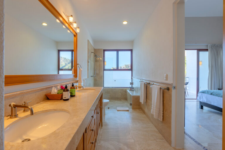 Villa Magnifico Modern bathroom with marble floors, double sink, and walk-in shower. Located in Mismaloya, near Puerto Vallarta.
