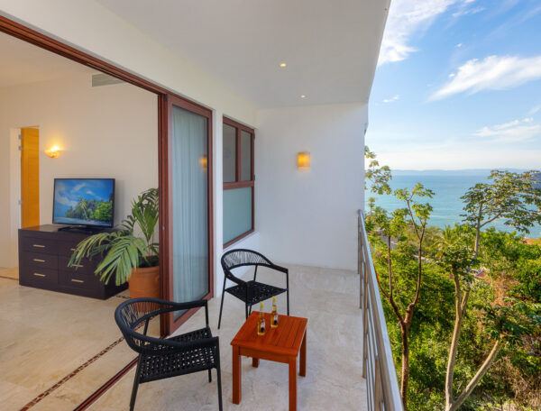 Villa Magnifico Balcony with chairs and table, overlooks lush greenery and ocean view, Mismaloya near Puerto Vallarta, Mexico.