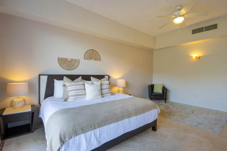 Villa Magnifico Luxury Mismaloya Villa near Puerto Vallarta: Spacious neutral-toned bedroom with bed, bedside tables, lamps, ceiling fan, and cozy chair.