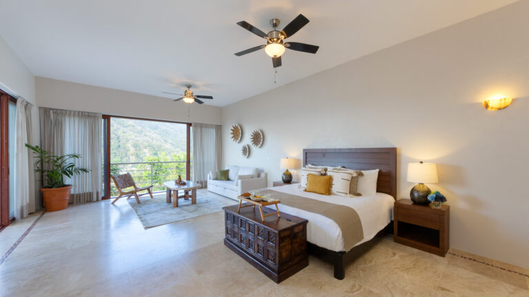 Villa Magnifico Luxury villa bedroom in Mismaloya, near Puerto Vallarta: spacious with neutral decor, large bed, and garden views.