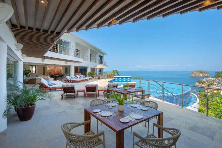 Villa Magnifico Luxurious villa in Mismaloya near Puerto Vallarta: Terrace with dining, infinity pool, sun loungers, overlooking ocean and hills.