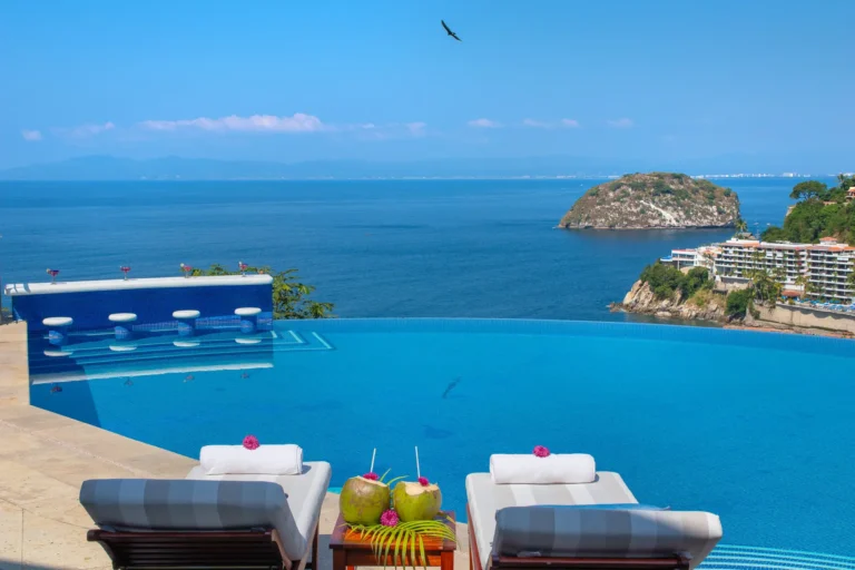 Villa Magnifico Luxury villa in Mismaloya, near Puerto Vallarta: Infinity pool, ocean view, island afar; lounge chairs with coconuts.