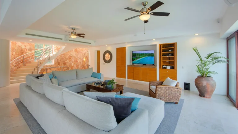 Villa Magnifico Luxury Villa in Mismaloya, near Puerto Vallarta: Spacious living room with L-shaped sofa, stone accent wall, and flat-screen TV.