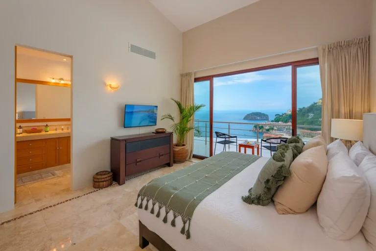 Villa Magnifico Ocean-view bedroom with a balcony, large bed, and attached bath in Mismaloya, near Puerto Vallarta, Mexico.