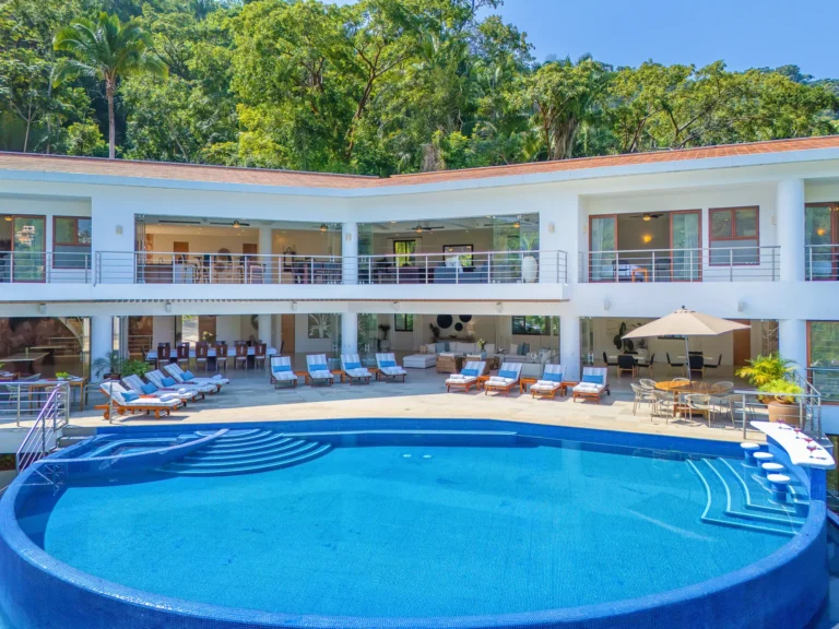 Villa Magnifico Luxury modern villa in Mismaloya, near Puerto Vallarta, with infinity pool, balcony, and lush tree backdrop.