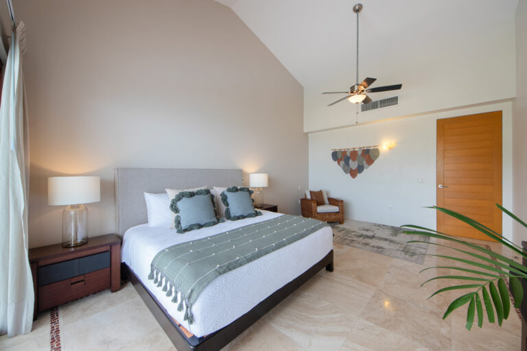 Villa Magnifico Elegant bedroom with high ceiling, green accents, and potted plant in luxurious Mismaloya Villa near Puerto Vallarta, Mexico.