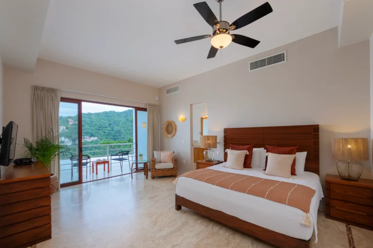 Villa Magnifico Spacious bedroom in Mismaloya villa near Puerto Vallarta, Mexico; wood bed, balcony with views of lush green hills.