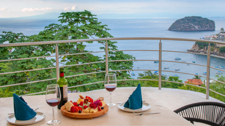 Villa Magnifico Luxury Villa in Mismaloya: Ocean view with boats, island; table set for two with wine, fruit, cheese.