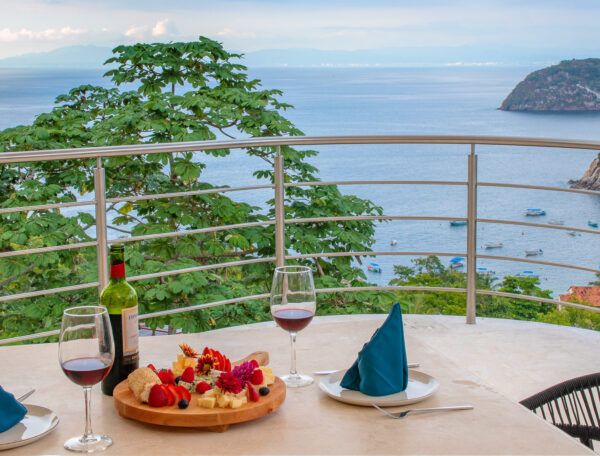 Villa Magnifico Ocean view from a Mismaloya villa balcony, near Puerto Vallarta: table for two with wine, cheese, and fruits.