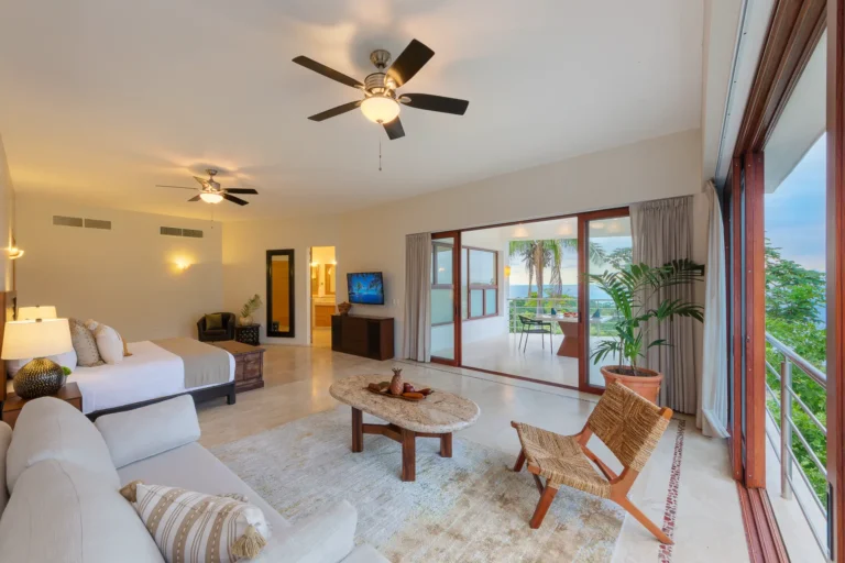 Villa Magnifico Spacious hotel room with double beds, seating area, ocean-view balcony in Mismaloya near Puerto Vallarta, Mexico.