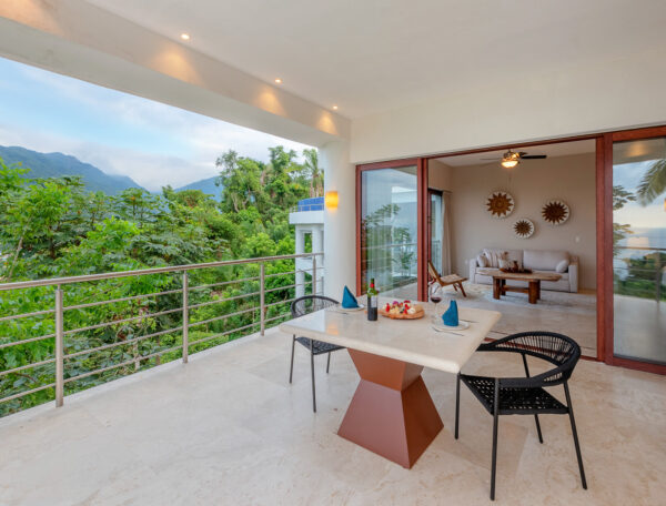 Villa Magnifico Balcony dining area with mountain views in luxury Villa, Mismaloya, near Puerto Vallarta; sofa and mirrors inside.