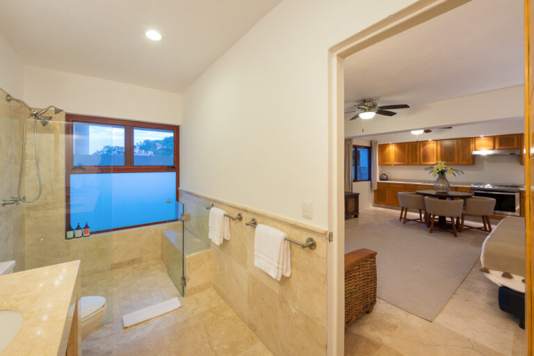 Villa Magnifico Luxurious Villa in Mismaloya: Bathroom leads to living area with dining table, kitchen, fan, and natural light.