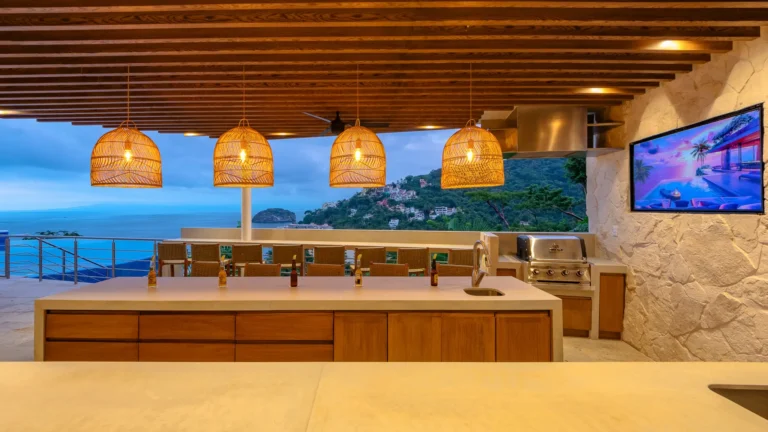 Villa Magnifico Luxury villa in Mismaloya, near Puerto Vallarta: Outdoor kitchen with ocean view, grill, TV, wicker lights.