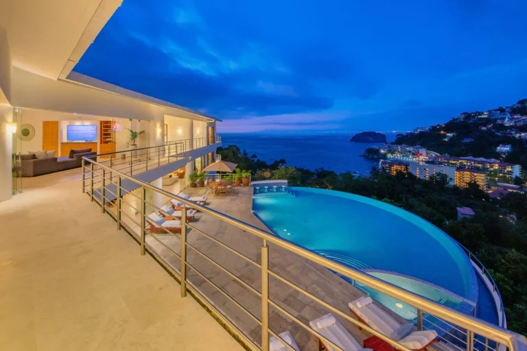 Villa Magnifico Mismaloya, near Puerto Vallarta: Balcony with infinity pool merging into ocean view; loungers and umbrellas on patio.