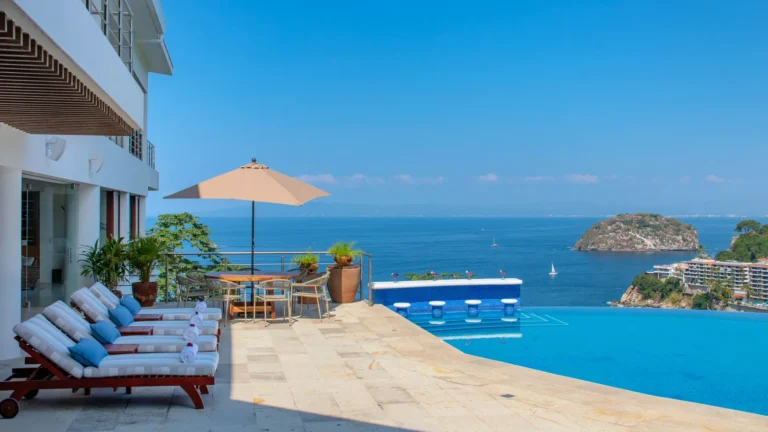 Villa Magnifico Luxury Villa terrace in Mismaloya, near Puerto Vallarta, with infinity pool, sun loungers, and ocean view.