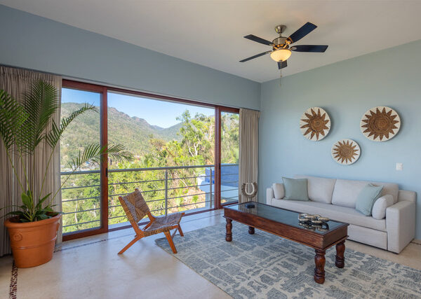 Villa Magnifico Living room in luxury Villa, Mismaloya near Puerto Vallarta, showcases white sofa, sunbursts, and mountain views.