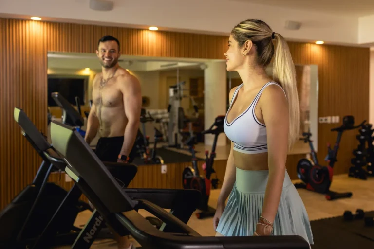 Villa Magnifico A woman watches a shirtless man cycling in a modern gym at Mismaloya luxury villa, near Puerto Vallarta.