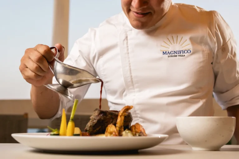 Villa Magnifico In Mismaloya, near Puerto Vallarta, a chef pours sauce on a gourmet dish at Magnifico Luxury Villa.