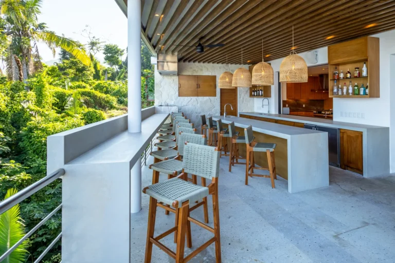 Villa Magnifico Luxury villa's outdoor bar in Mismaloya, near Puerto Vallarta, Mexico; features high stools and a lush backdrop.