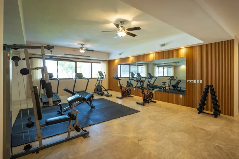 Villa Magnifico Modern gym in luxury Villa, Mismaloya near Puerto Vallarta, features weights, machines, mirrors, tiled floors, ceiling fans.
