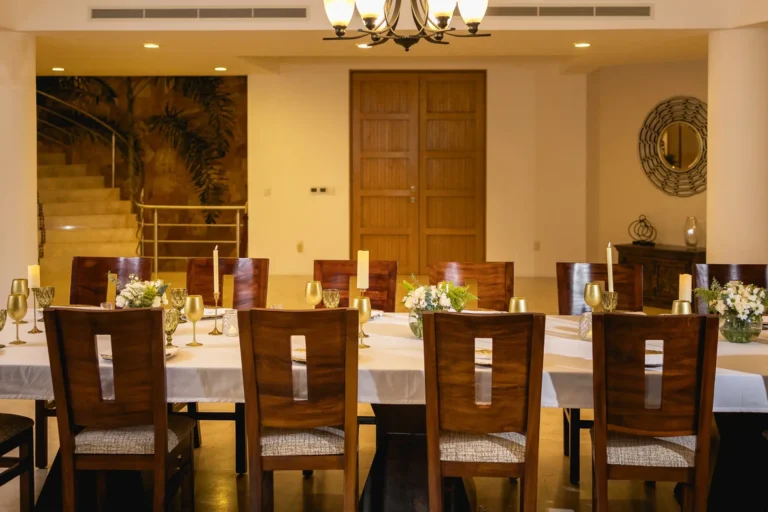 Villa Magnifico Luxury villa dining room in Mismaloya, Puerto Vallarta: Elegant table with decor, wooden chairs, staircase behind.