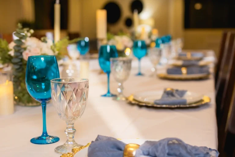 Villa Magnifico Dining table set with blue-tinted glasses, white plates, candles, at luxury Villa in Mismaloya near Puerto Vallarta.