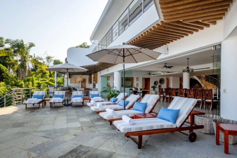 Villa Magnifico Luxurious Villa: Mismaloya near Puerto Vallarta, Mexico; outdoor patio with lounge chairs, umbrellas, and lush greenery.